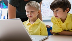 School children looking at laptop